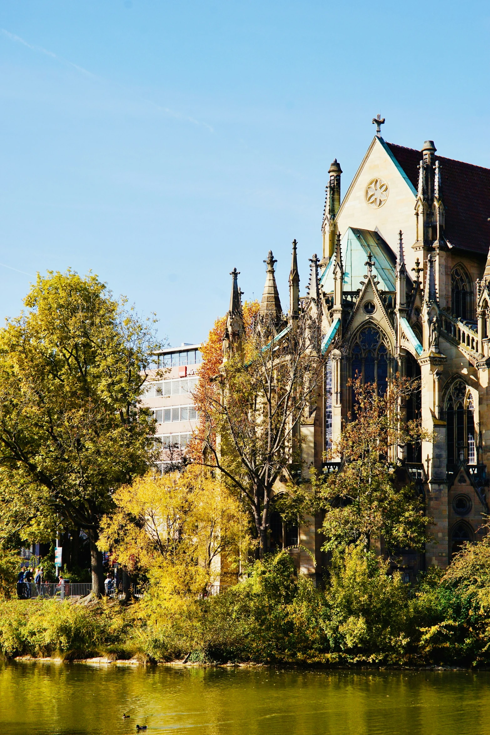 large cathedral in a park setting with trees on both sides