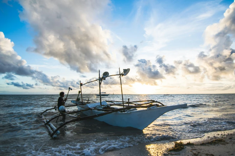 an old boat washed ashore in the ocean at sunset