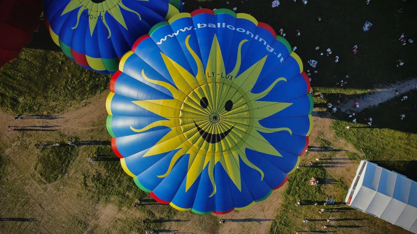 several colorful air balloons being flown in a field