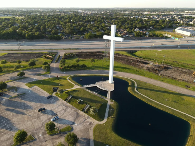 an aerial view of a large white cross in a field