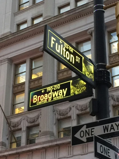 street signs in front of a building at fulton st