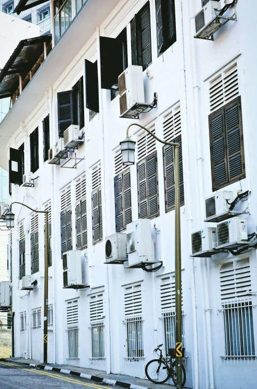 a long building is white with windows and shutters