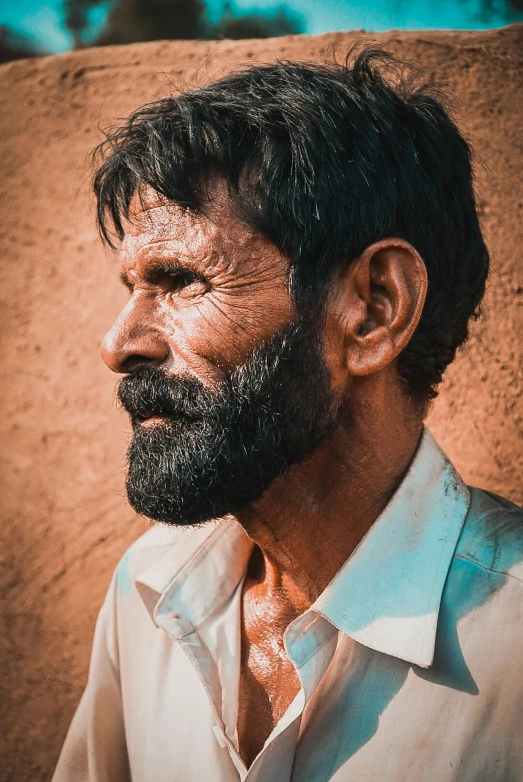 a portrait of an older man wearing a long sleeve shirt