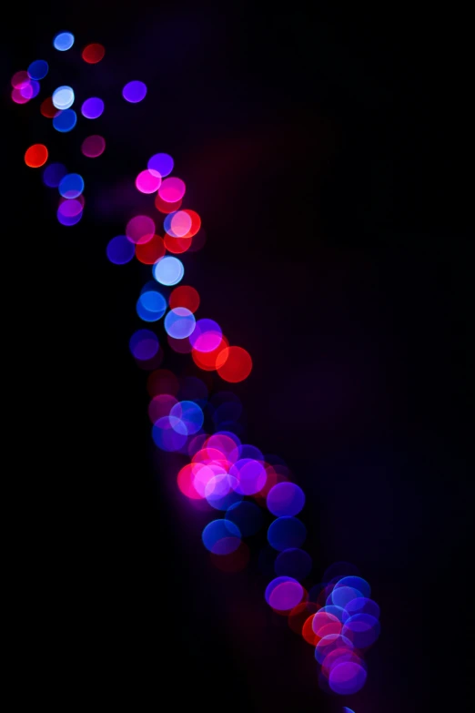 a colorful blurry po of lights on a dark background