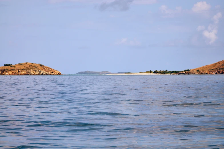 a body of water with small islands in the distance