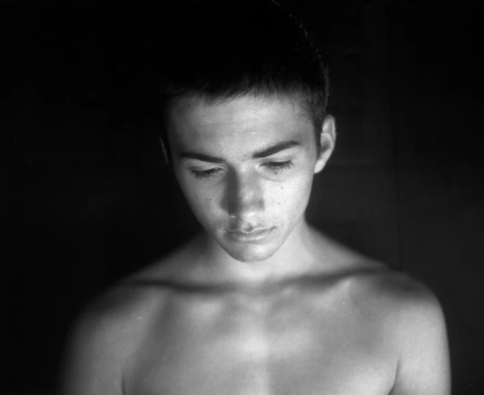 a black and white po of a shirtless man with his eyes closed