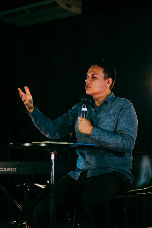 a man with hands up while seated at a table