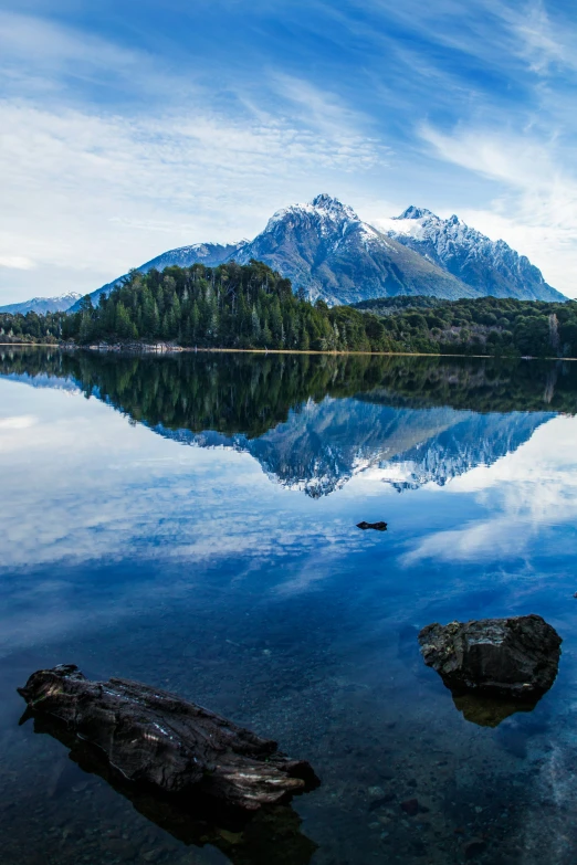 the mountains are reflected in the still waters