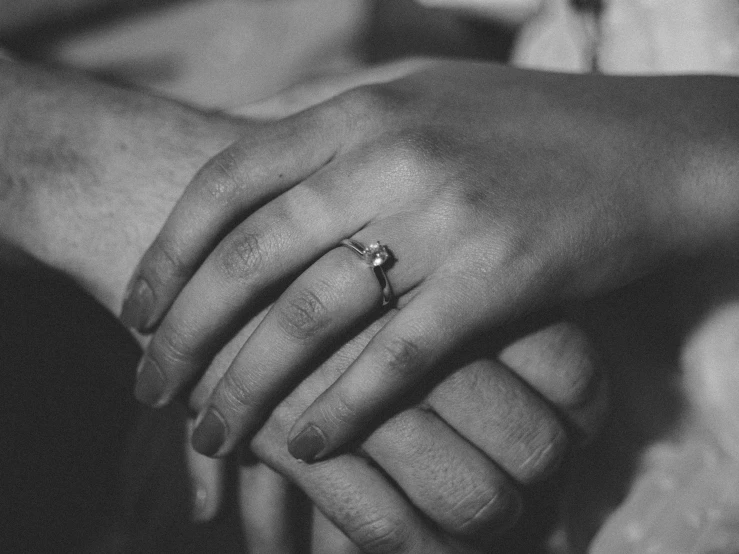 two people holding hands in black and white