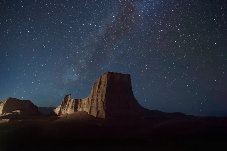 a mountain in the sky is shown with stars above it