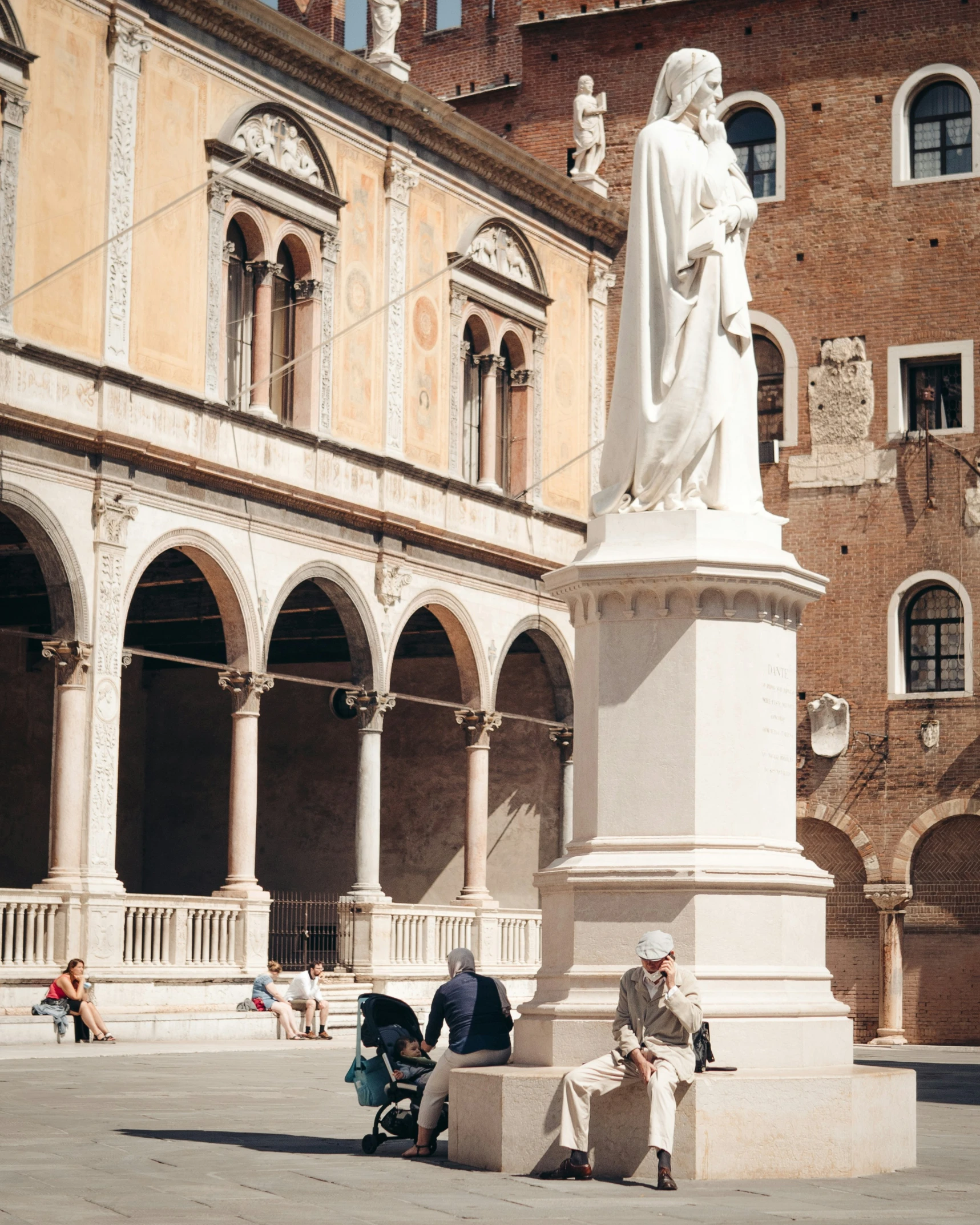 two men sitting on benches with a statue behind them