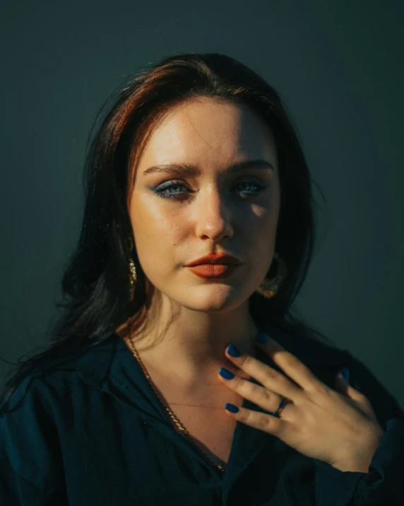 a woman in a black shirt with blue eyes and large ring