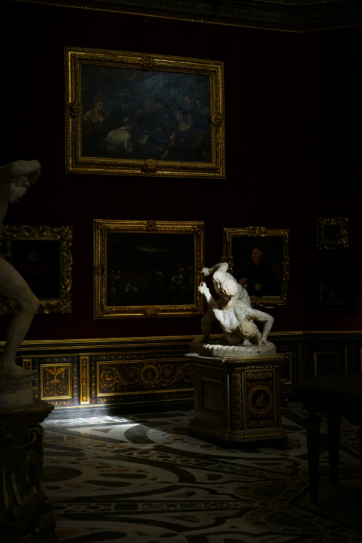 some sculptures are sitting in a room with a painting