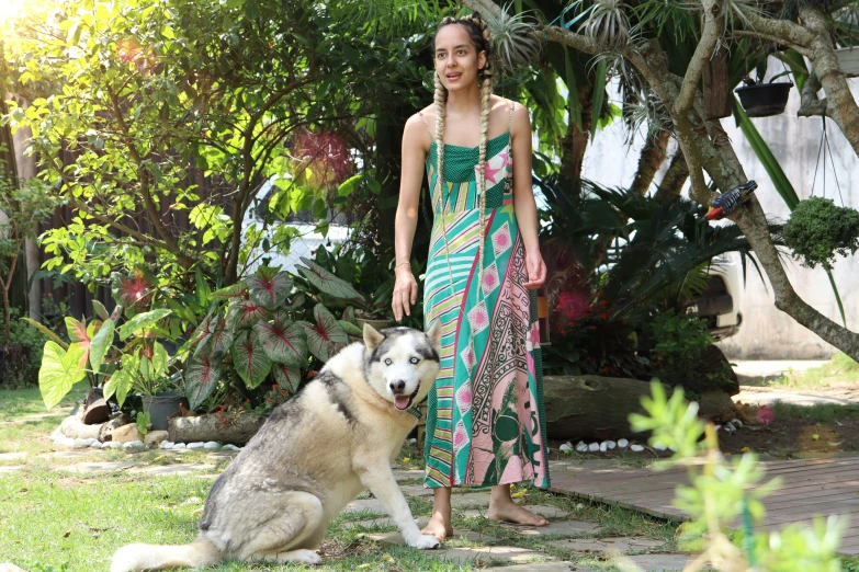 woman and husky dog at backyard setting with bushes