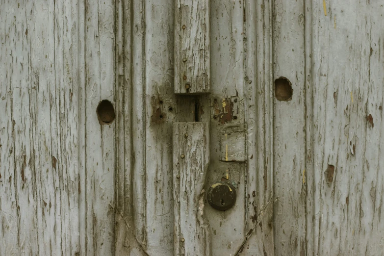 an old white painted door with rusted handles