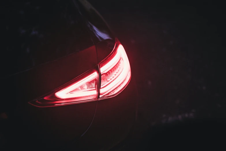 a rear light shining on a vehicle in the dark