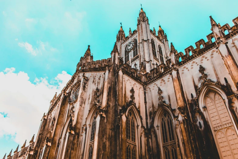 a very tall cathedral sitting on top of a blue cloudy sky