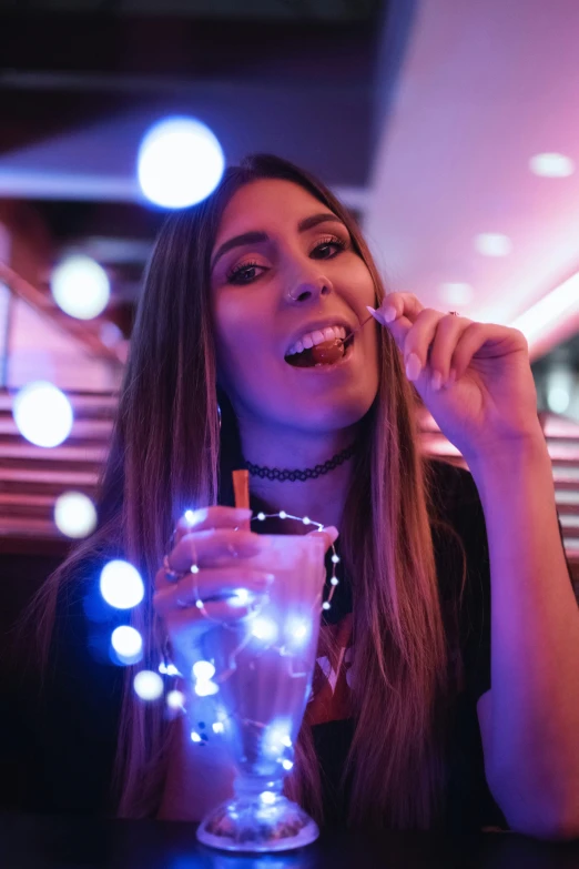 woman drinking a cocktail with a smile on her face