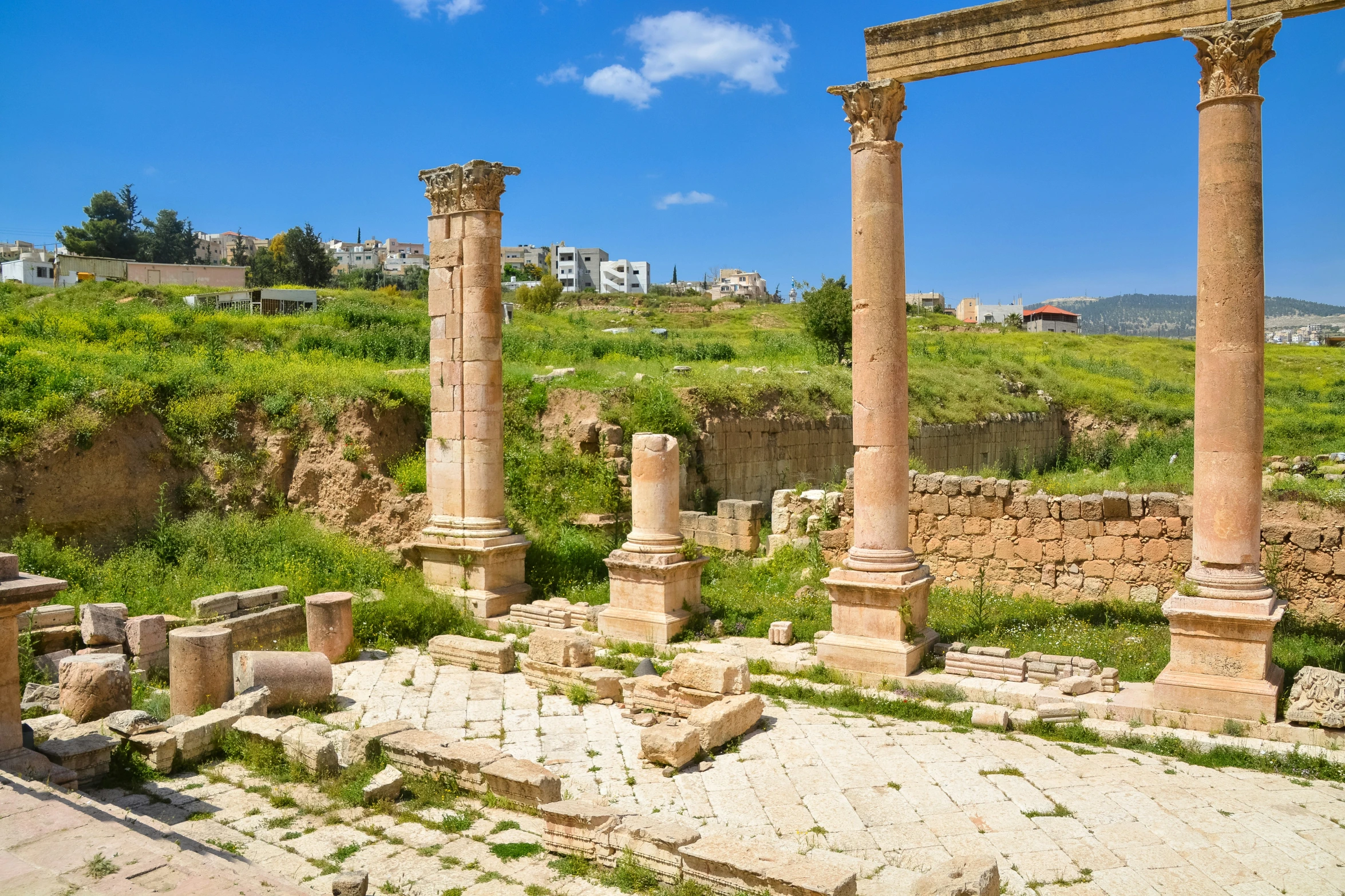 an old roman city has green vegetation on the ground