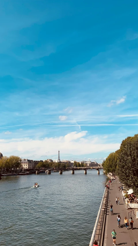 a group of people on bikes riding along a road with a river in the distance