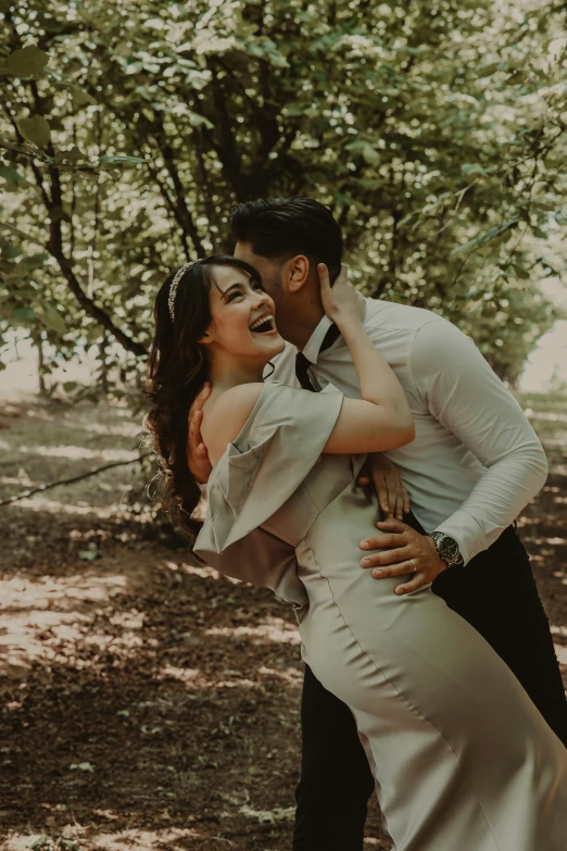 a bride and groom kissing each other near the woods