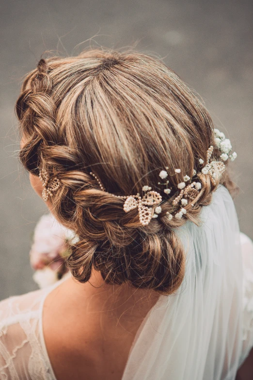 a bride with her hair pinned back with pearls and flower