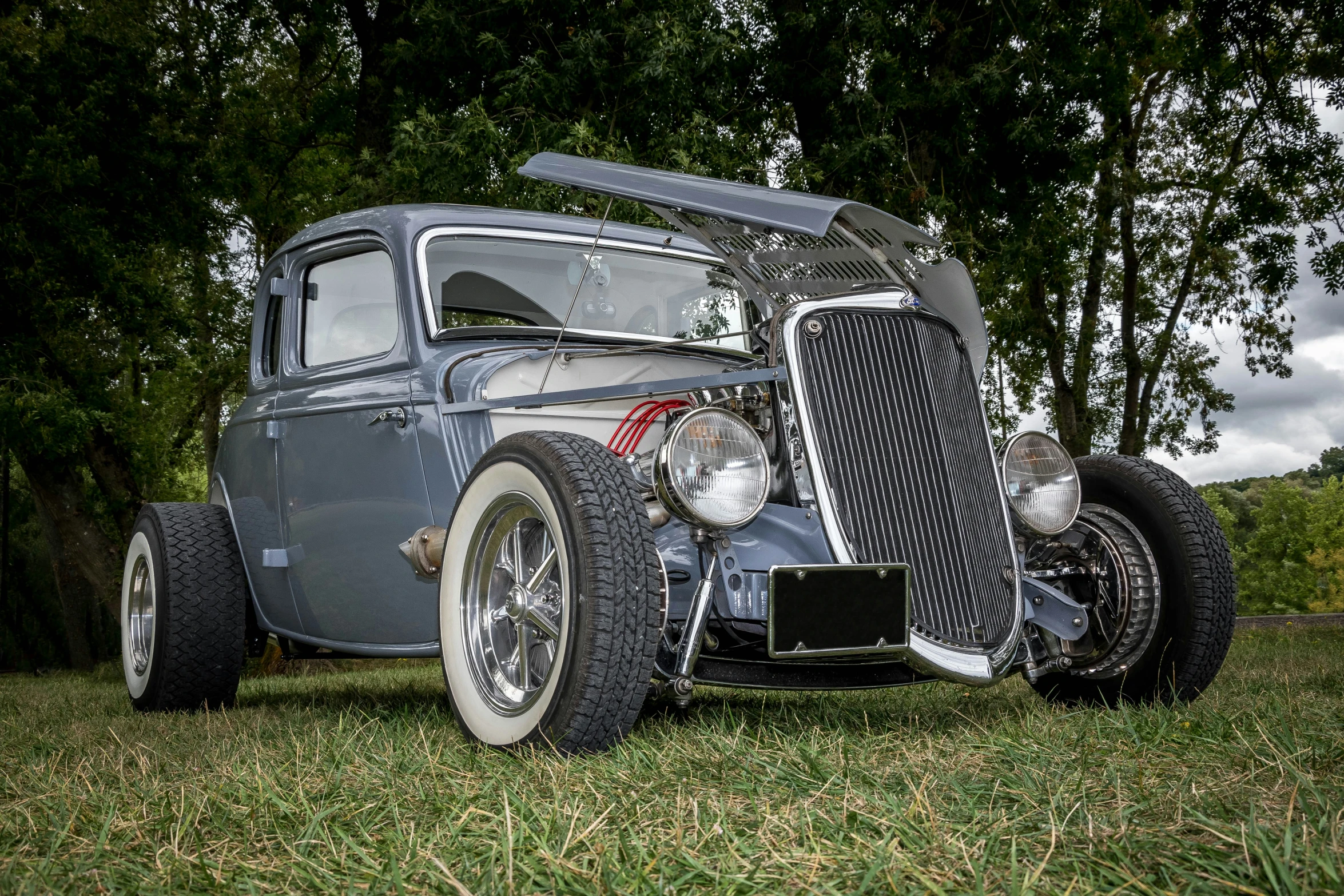 an old time car is sitting in the grass