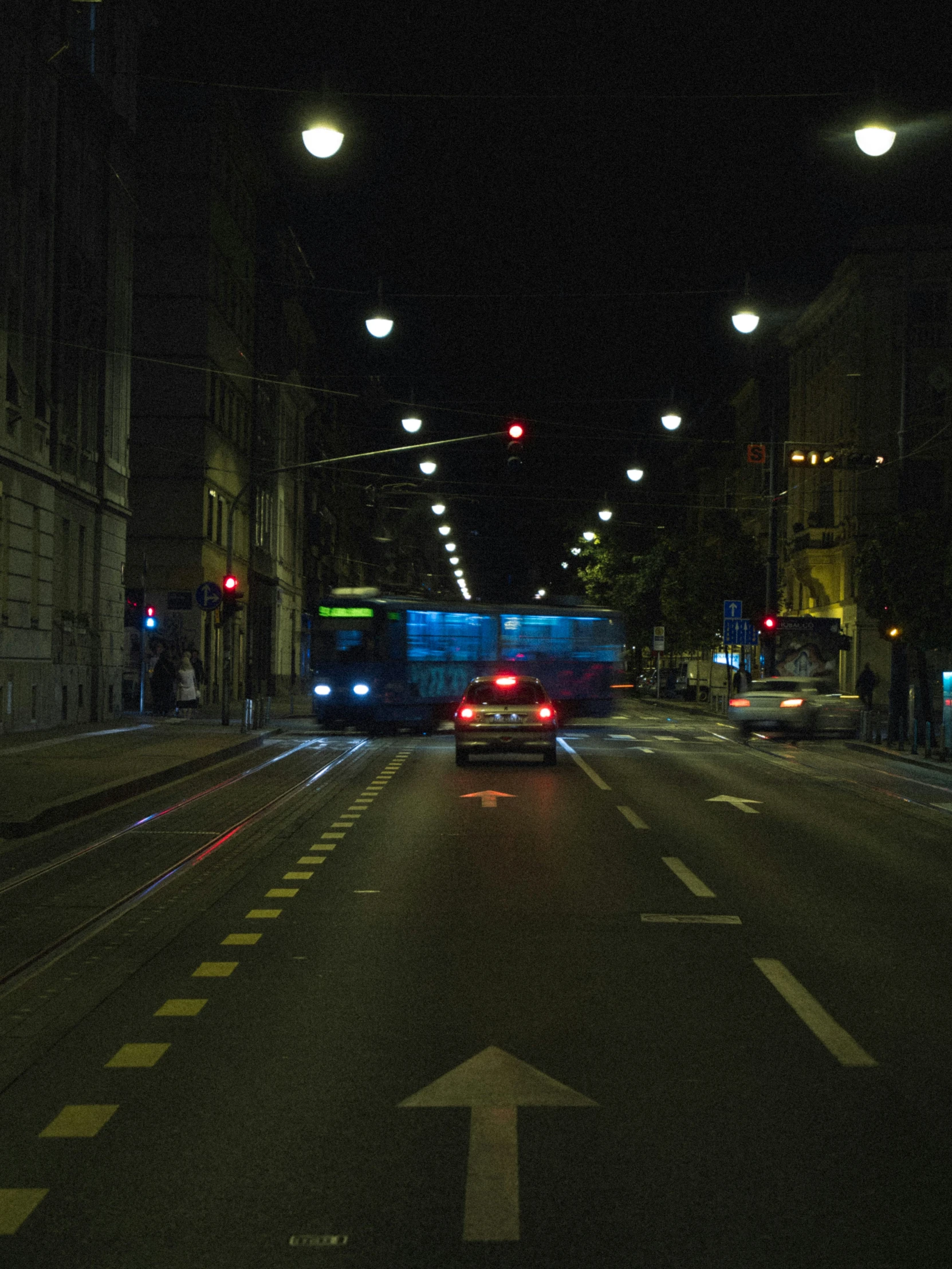 a large bus drives on the streets at night