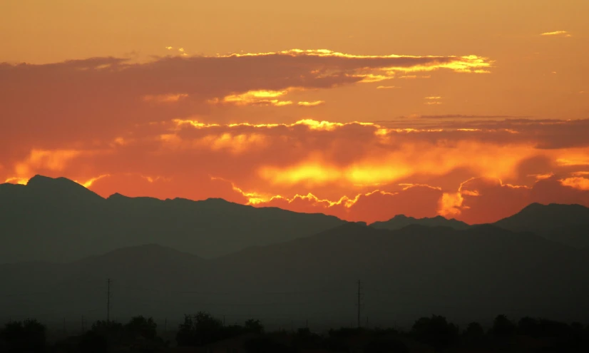 a sunrise behind the mountains, and some clouds