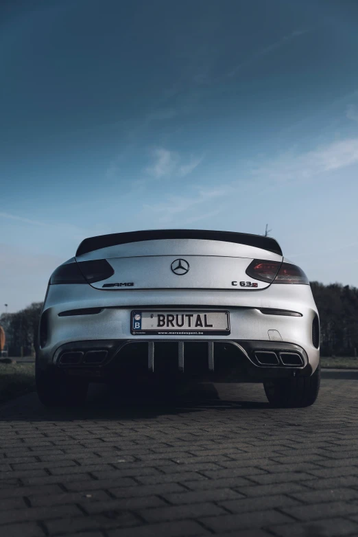 a silver sports car is parked on a cobblestone area