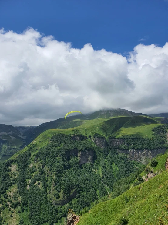 a kite is flying high up on a hill