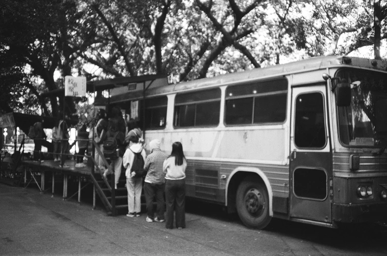 black and white po of people standing in front of a bus