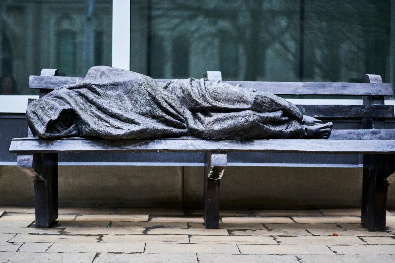 a large gray blanket is lying on a bench