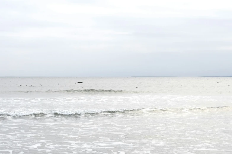 a man standing on a beach next to the ocean