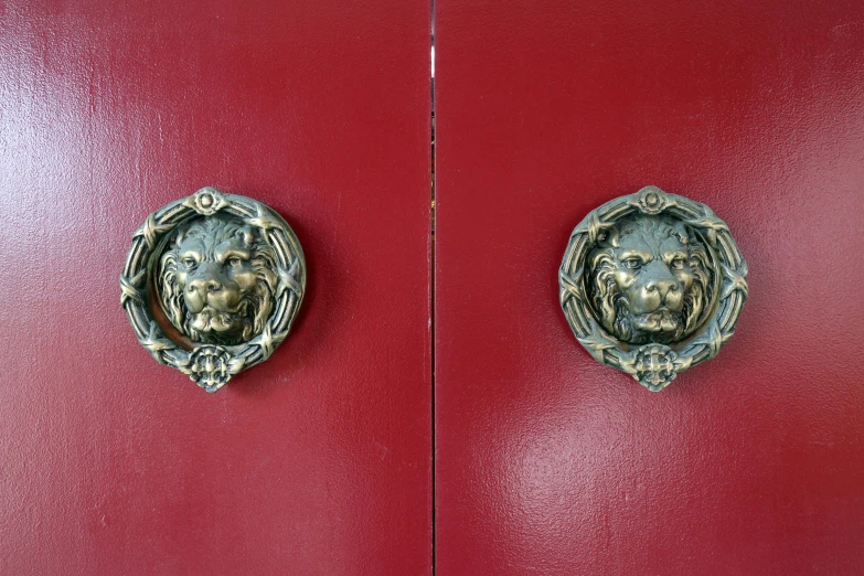 two handles of a red and gold painted door