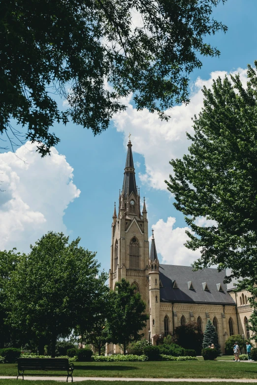 an old church near trees under the blue sky