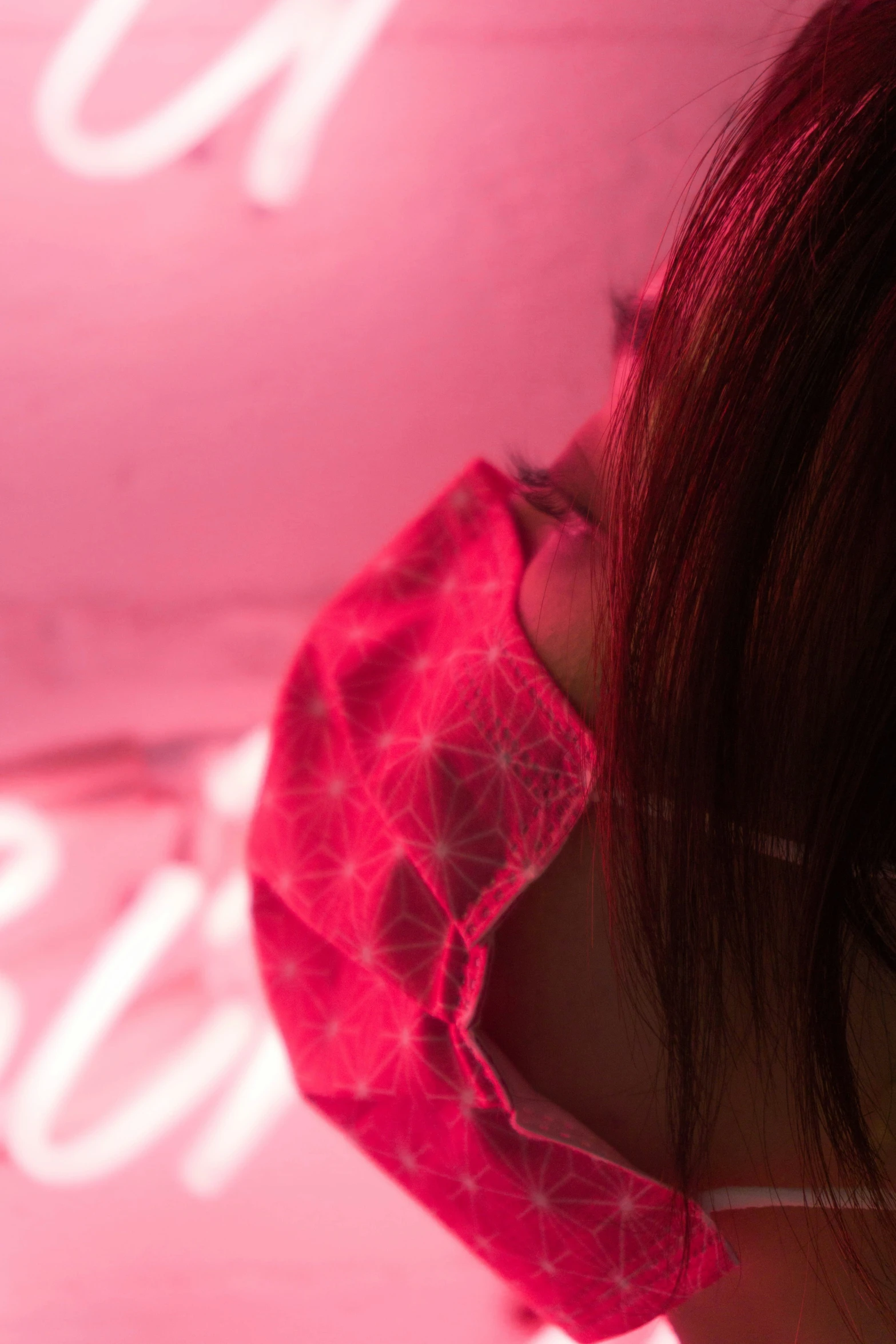 a woman in a pink top is looking at a pink background