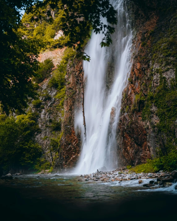 the view of a waterfall from below from ground level