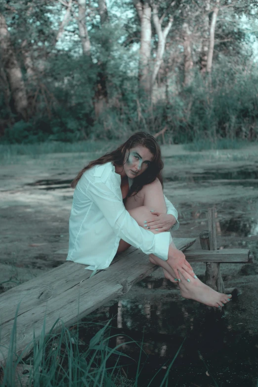 young woman seated on plank in an image with water