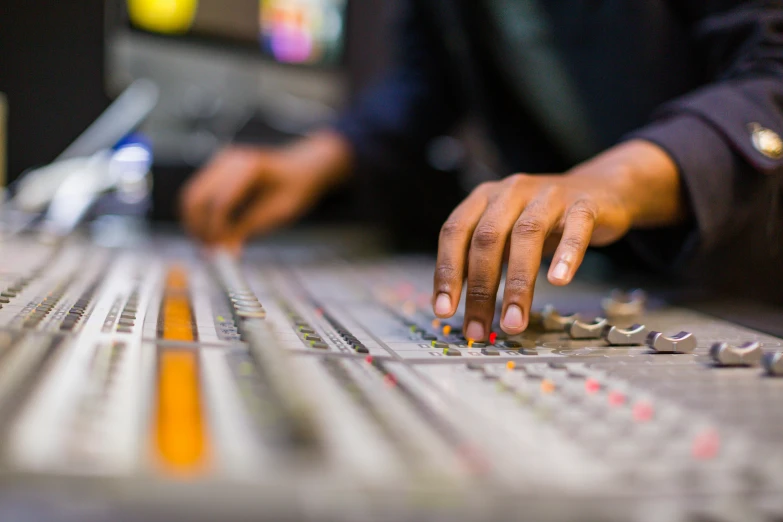 a person working on a sound board in a recording studio