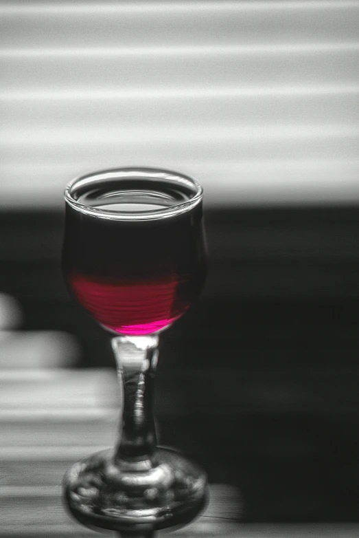 a glass is full with red liquid on a table