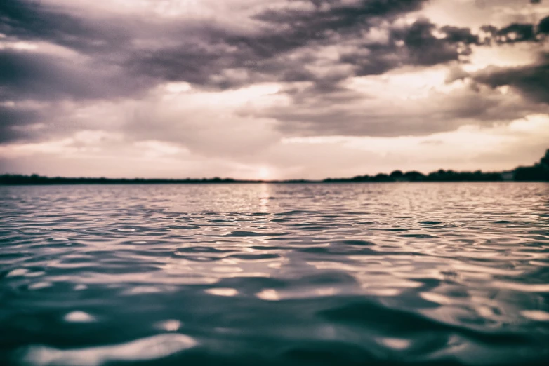 a large body of water that is under a cloudy sky