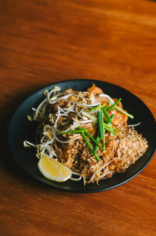 a plate of food that includes shredded grass, limes and chicken