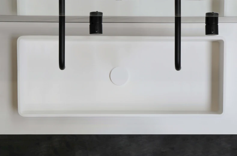 a white square sink hanging from hooks over a wall