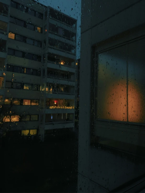 dark window at night with a city in the background