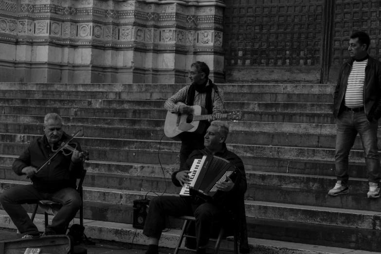 the men are playing music on the steps