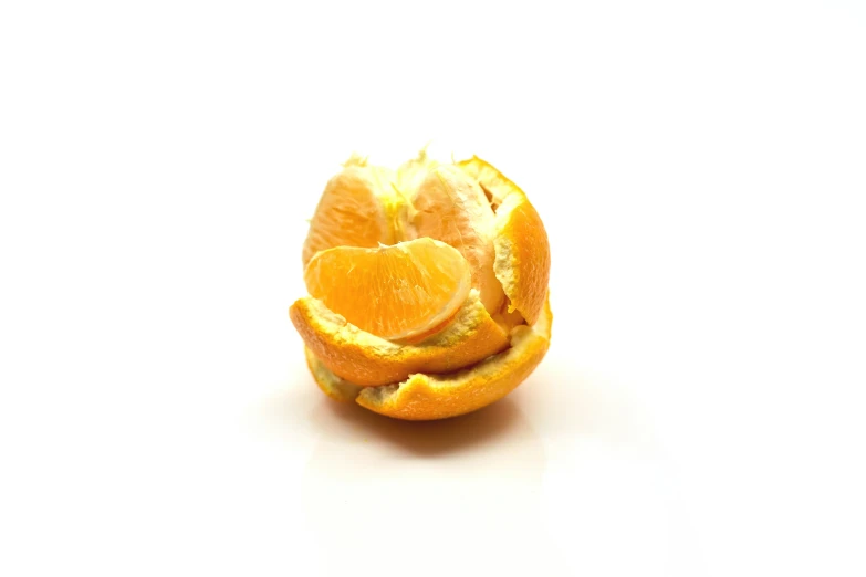 a peeled orange on a white background cut in half