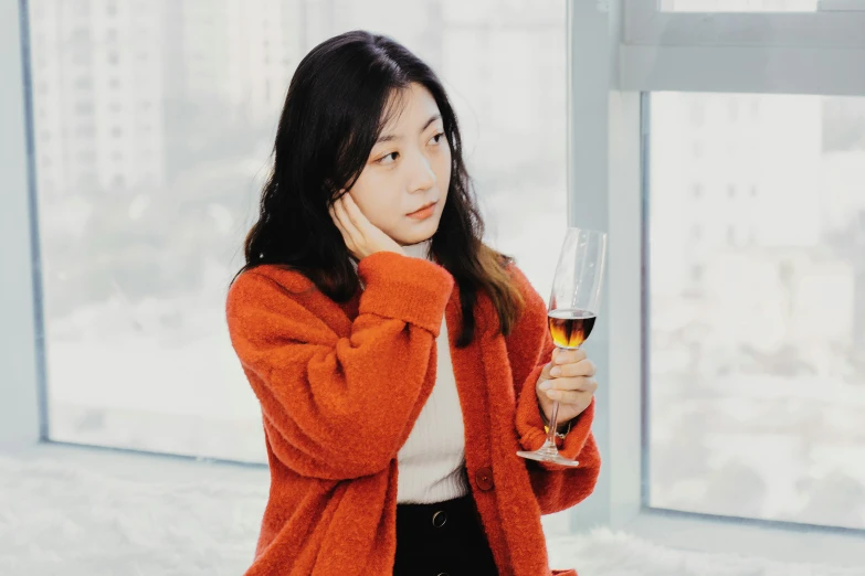 a girl holding a glass of wine in her hand