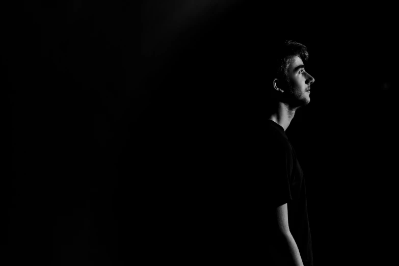 a man standing in the dark looking away