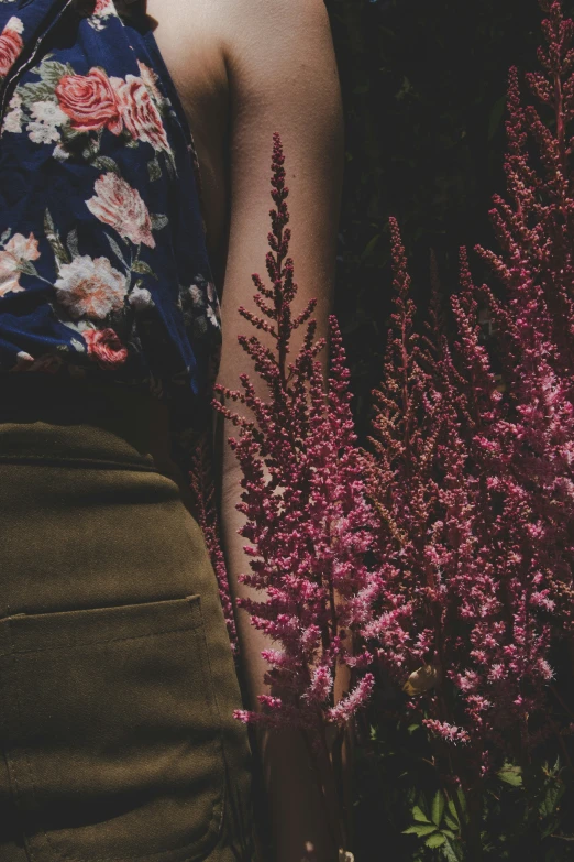 a woman in a flowered top holds a flowery bouquet